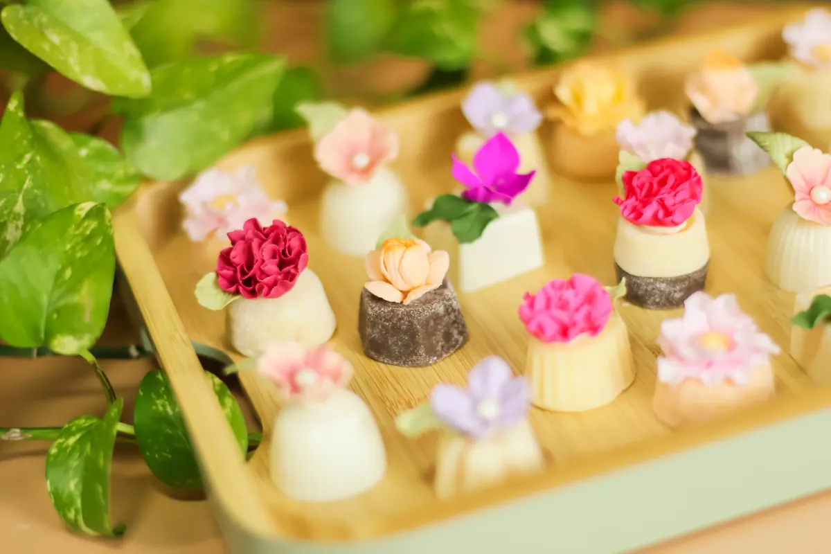 Bandeja com doces finos decorados com flores de açúcar coloridas